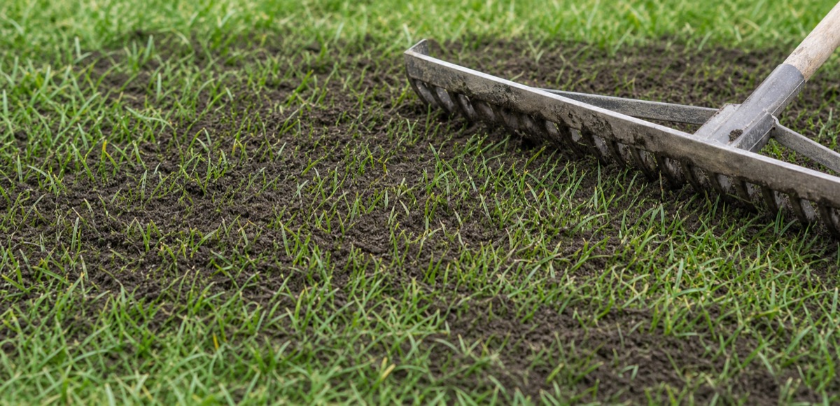 Fine screened topsoil beside a soil sieve and rake